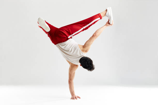 istock Modern dancer stands on one hand freeze with hands splitted out in air on white 2162052765