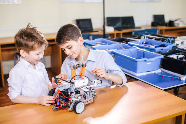 istock Two brothers kids playing with robot toy at school robotics class, indoor. 2162053058