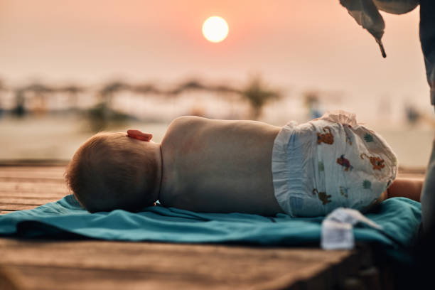 Sleepy baby at tropical paradise beach during sunset.