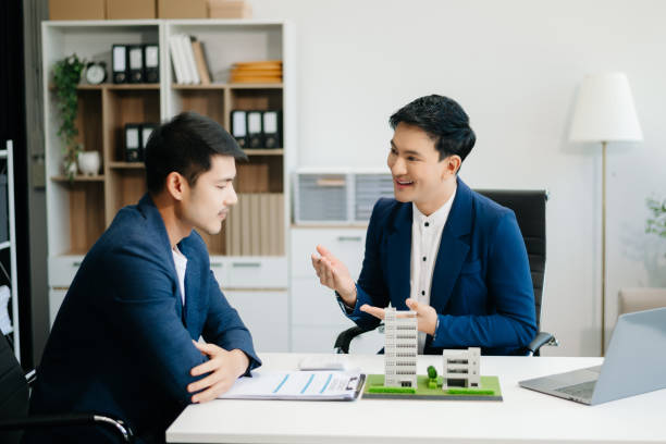 istock Young real estate agent worker working with laptop and tablet at table in office and small house 2162066220