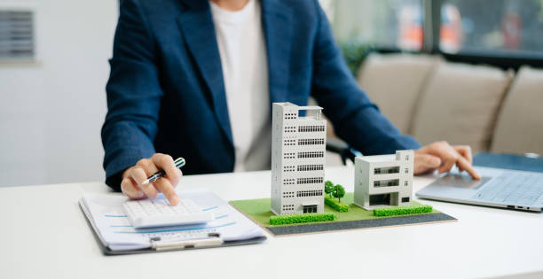 istock Young real estate agent worker working with laptop and tablet at table in office and small house 2162066222