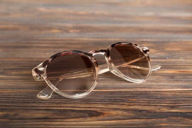 sunglasses with seashell lying on table background. Sunglasses on summer background. Top view flat lay with copy space for text.