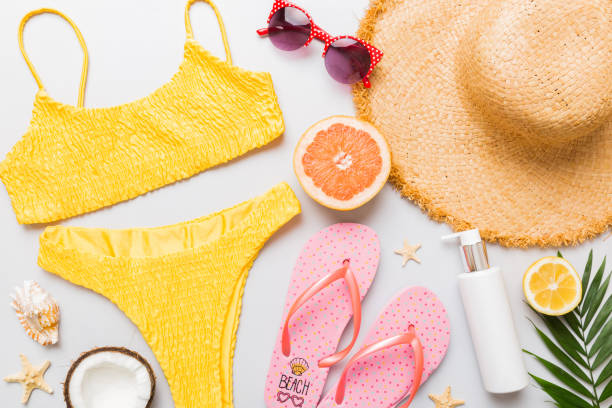 istock Swimming pool accessories concept. Top view of beach items on table, bright bikini, straw hat, and sunscreen skincare cream. Colorful beach wear. top view Flat lay, copy space 2162067163