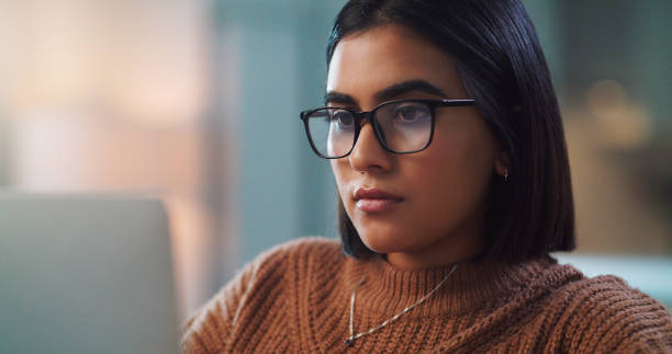 Shot of a young woman using a laptop while studying at home