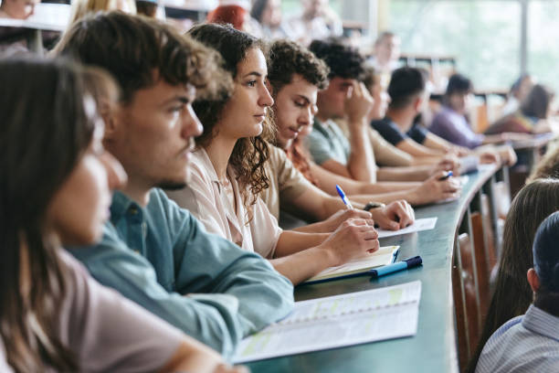 istock Young female student and her friends having a class in lecture hall. 2162067450