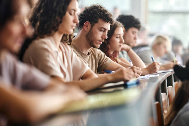 istock Male college student writing an exam in lecture hall. 2162068387