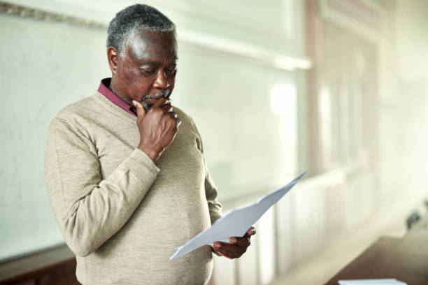 istock Black male professor going through paperwork lecture hall. 2162068426