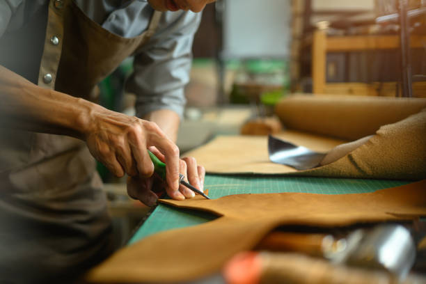 istock Cropped shot of artisan working on the workbench with different rolls brown leather 2162068442
