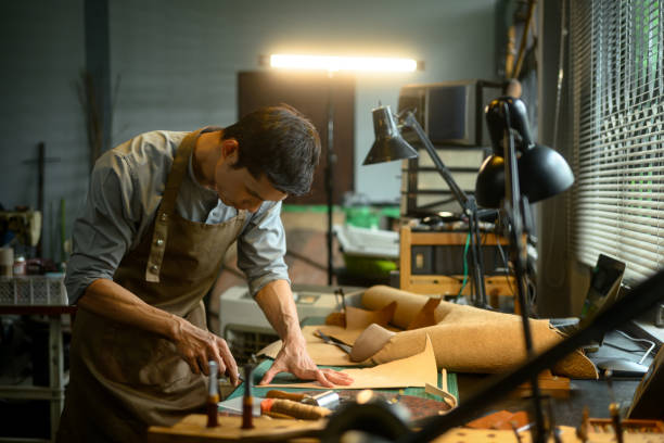 istock A craftsman working diligently, cutting leather in his workshop with various tools 2162068445