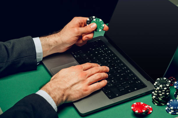 istock Person Playing Online Poker Game With Laptop and Chips 2162068547