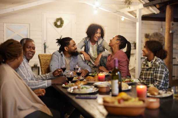 istock Happy black extended family having dinner at picnic table by night. 2162069193