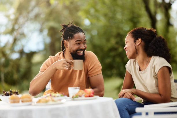 Happy black couple talking during a meal in the backyard.