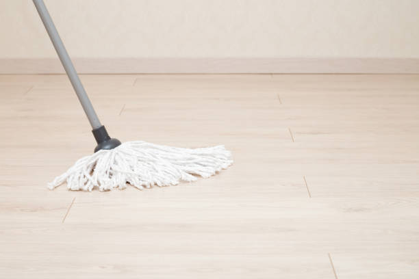 istock White soft mop head with plastic stick washing light laminate floor. Regular home, office or other places cleaning. Front view. Closeup. 2162069261