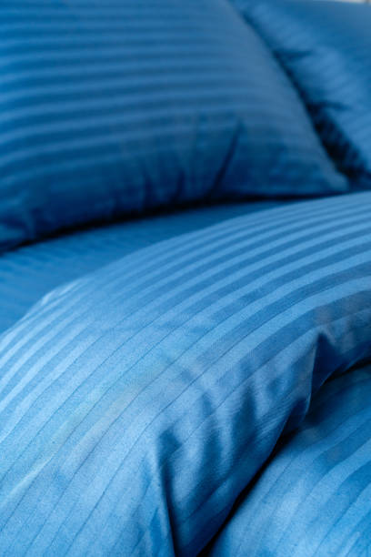 istock Blue Striped Bedding on a Black Metal Bed Frame in a Modern Bedroom 2162070091