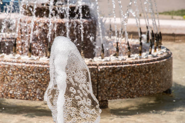 Sparkling water from fountain in city park on sunny summer day
