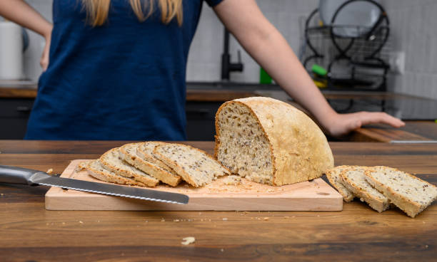 Bread sliced ​​on the kitchen counter, a loaf of white bread with linseed close-up