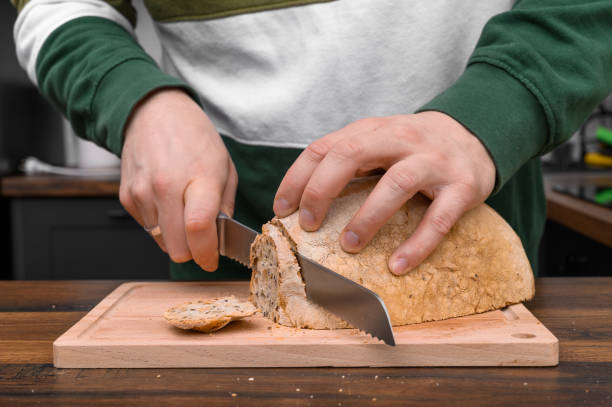 istock A man cuts homemade crusty bread for breakfast, an addition to cold meats 2162071927