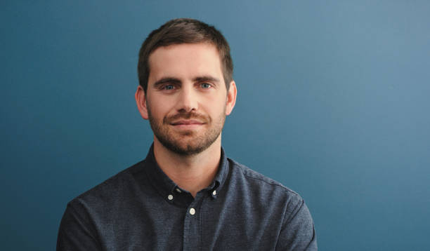 istock Studio shot of a young man standing against a blue background 2162072999