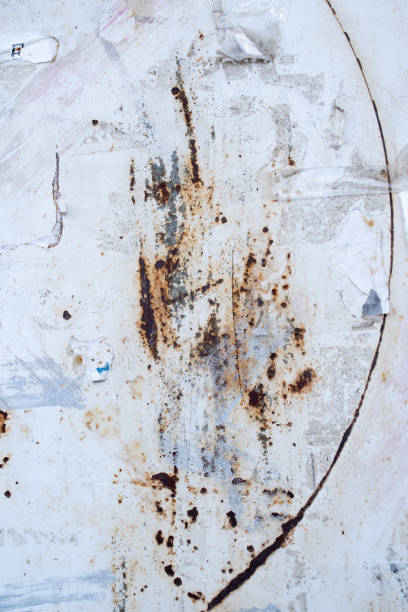 istock Old iron wall with white paint and rusty scratches background 2162074800