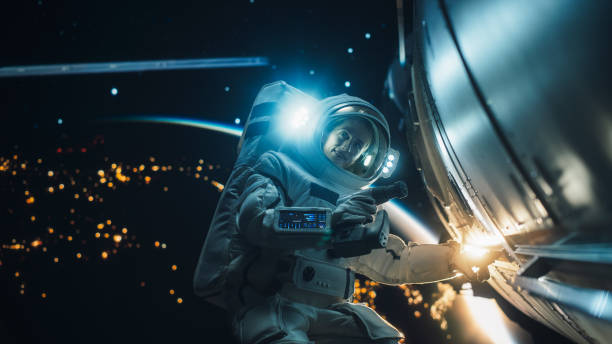 Caucasian Female Space Technologist Repairing a Panel on a Spacecraft with an Automatic Screw Gun. Professional Astronaut Working in Outer Space with Dark Illuminated Planet Earth in the Background