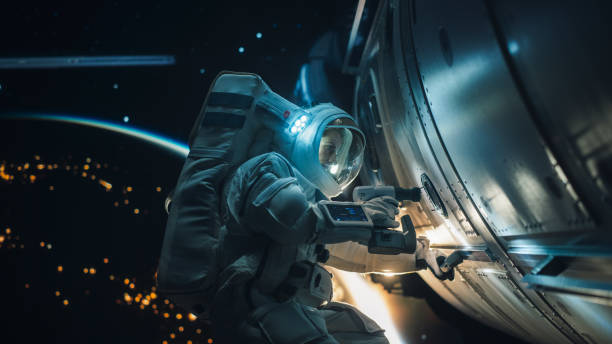 istock Female Space Technologist Repairing a Panel on a Spacecraft with an Automatic Screw Gun. Professional Astronaut Working in Outer Space with Dark Illuminated Planet Earth in the Background 2162076245