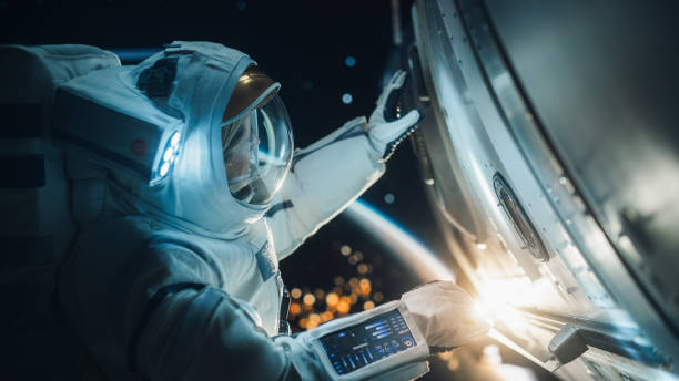 istock Professional Astronaut Performing a Routine Maintenance Check Outside a Spacecraft in Zero Gravity in Space. Advanced Space Technology, Scientific Exploration and Female Empowerment Concept 2162077014