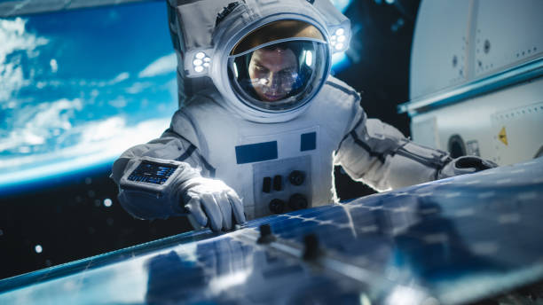 istock Astronaut on an Extravehicular Mission in Space Far From Planet Earth. Courageous Man Fixing and Adjusting the Angle on a Solar Panel Module Outside the Space Station During a Service Work 2162077122