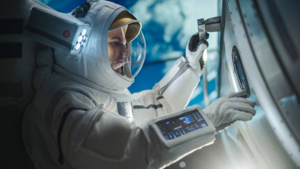 Portrait of a Handsome Young Astronaut Investigating a Satellite in Outer Space. Trained Professional in a Space Suit Performing Extravehicular Activity Outside the Spacecraft 3D graphics resources for earth - https://nasa3d.arc.nasa.gov/detail/ear0xuu2. The final backdrop was produced in Blender - open source 3D graphics software. space station stock pictures, royalty-free photos & images