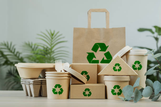 istock Use of eco-friendly paper tableware and packaging made from biodegradable materials. Set of eco friendly food packaging with recycling symbols on table white background. 2162078485