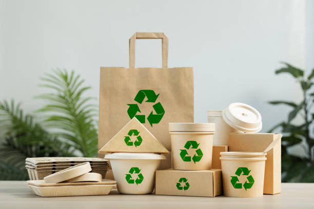 istock Use of eco-friendly paper tableware and packaging made from biodegradable materials. Set of eco friendly food packaging with recycling symbols on table white background. 2162078487