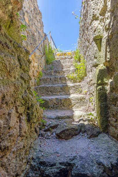 istock View upwards over an old stone staircase between a natural stone wall against a blue sky 2162078601