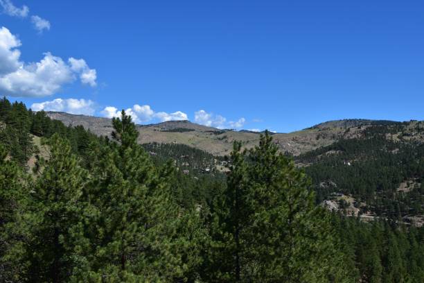 istock View of a forested mountain landscape under a clear blue sky with scattered clouds 2162083921