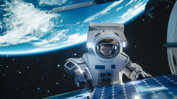 istock Astronaut on an Extravehicular Mission in Outer Space Far From Planet Earth. Courageous Man Fixing and Adjusting the Angle on a Solar Panel Module with a Screw Gun Outside the Space Station 2162084363