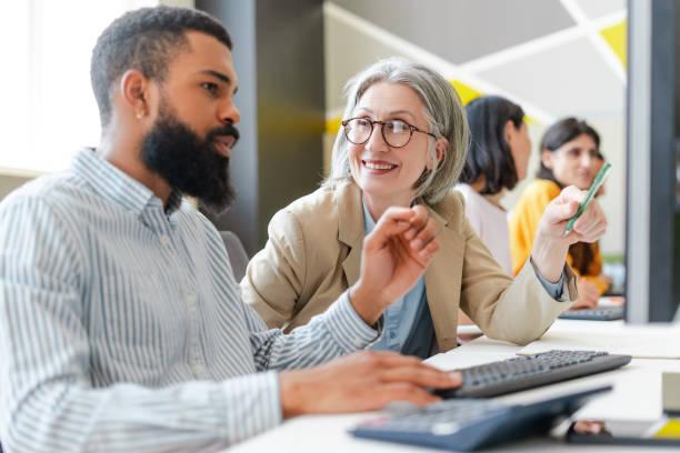 istock Coworkers collaborating and brainstorming on computer in office 2162085395