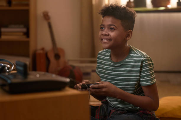 istock African American Boy Playing Video Games on Retro Console 2162086501
