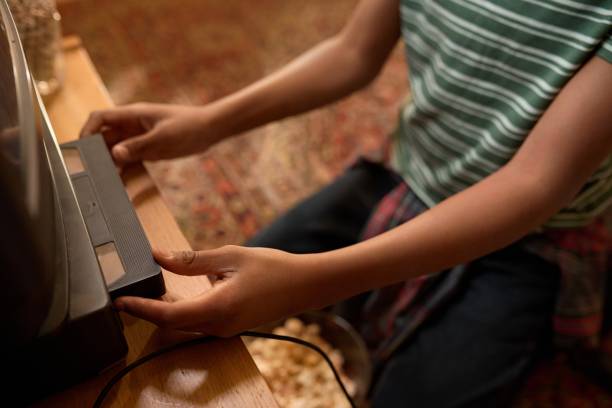 Unrecognizable Child Inserting Old-school VHS Tape into VCR