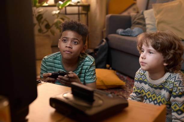 istock Two Friends Playing Retro Video Game at Home 2162086840