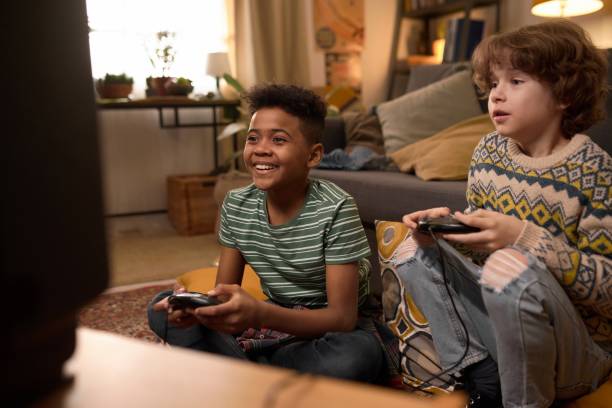 istock Smiling Boys Playing Retro Video Game Together 2162086850