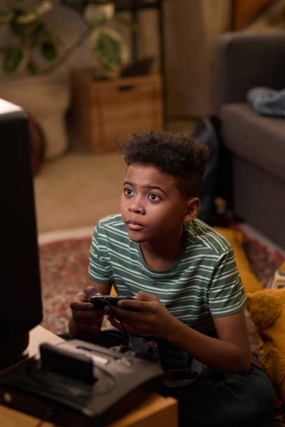 Focused Boy Playing Video Game Sitting on Floor