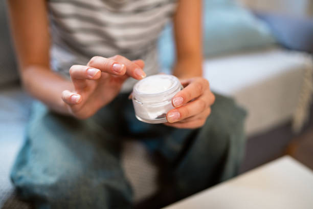 Redhead Caucasian teenage girl applying a face cream