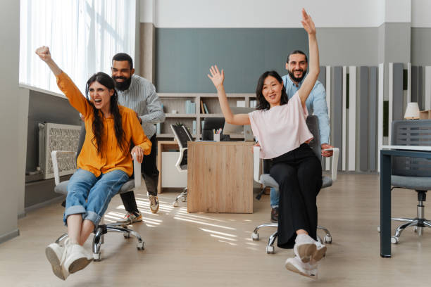 istock Happy multiethnic business team having fun racing on chairs in office 2162089696