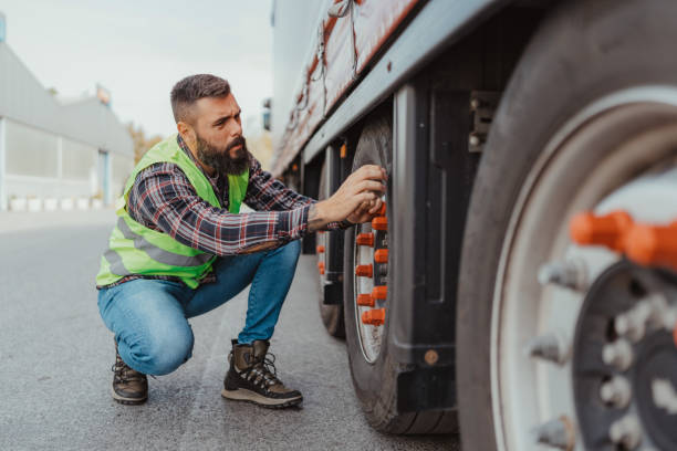 istock Truck driver adjusting tire demonstrating safety check 2162094572