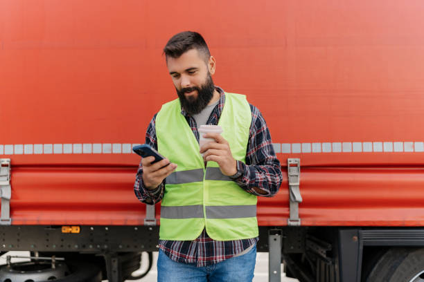 istock Truck driver using phone and coffee cup for break 2162094589