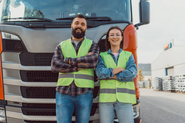 istock Two workers smiling in front of truck with folded arms. 2162094692
