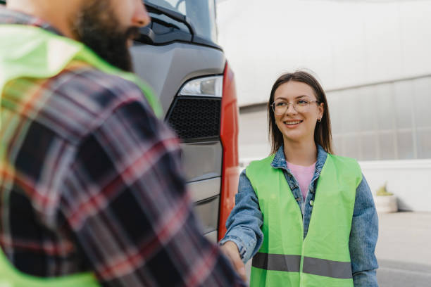 istock Worker greeting another with a handshake by truck 2162094710