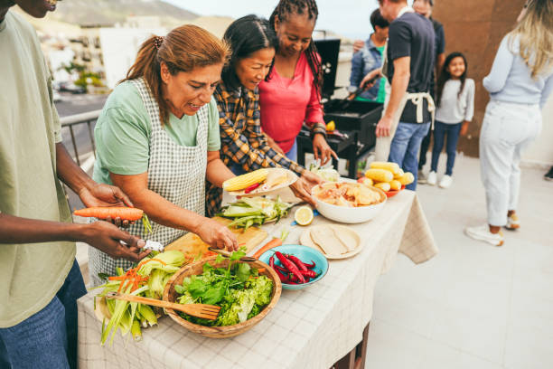istock Multigenerational people doing barbecue at home's rooftop - Multiracial friends having fun eating and cooking together during weekend day - Summer and food concept - Main focus on carrot 2162097103
