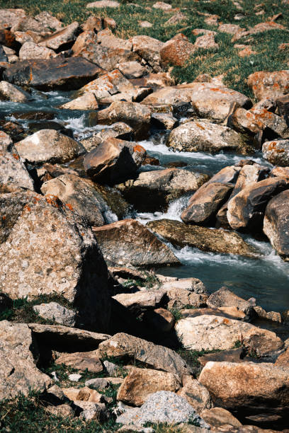 Winding blue stream navigating rocky shores in a mountain pass