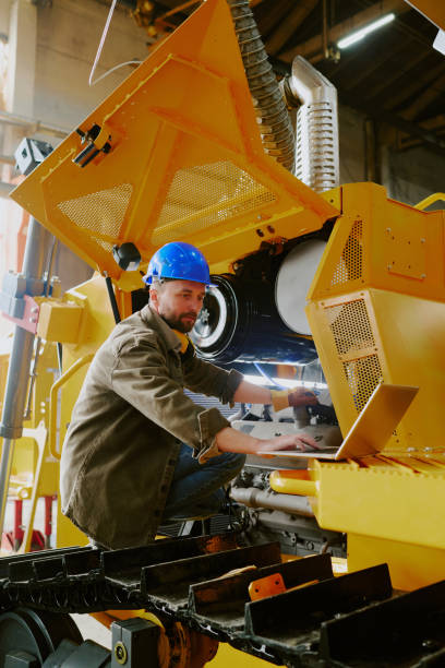 istock Technician Using Laptop While Fixing Parts Of Bulldozer 2162099423