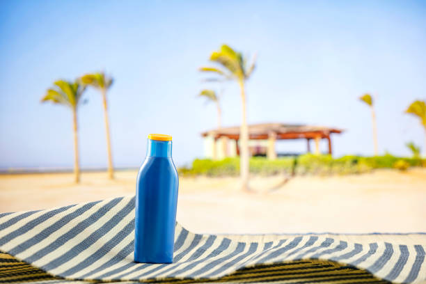 Beach stuff on beach mat on the table with the sea and the tropical beach on background.  Travel and vacation concept.
