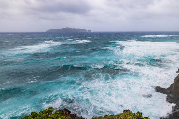 Peaceful ocean waves and fluffy white clouds over a serene blue sea in Bali, Indonesia. Perfect for vacation, relaxation, and nature concepts.